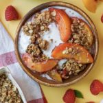 peach and raspberry crumble on a bamboo plate with melted ice cream