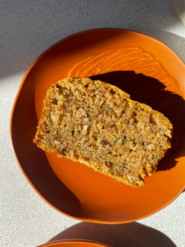 a slice of delicious zucchini bread on an orange plate