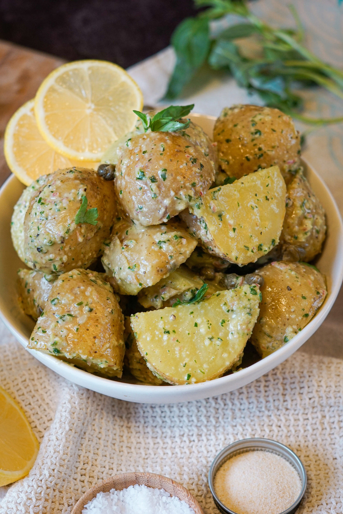 potato salad with lemons and herbs in a white bowl