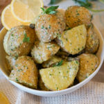 potato salad with lemons and herbs in a white bowl
