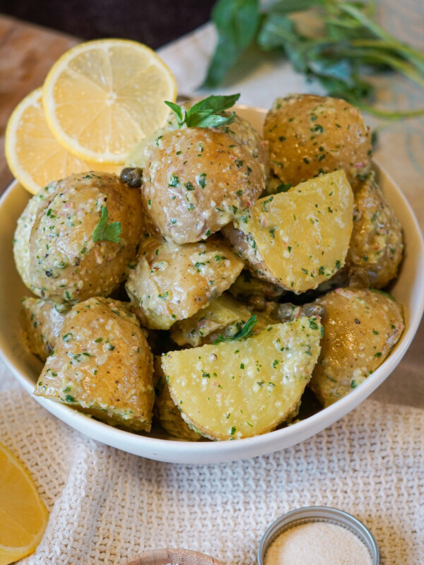 potato salad with lemons and herbs in a white bowl