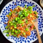 vegetable fried rice topped with shelled edamame and toasted cashews