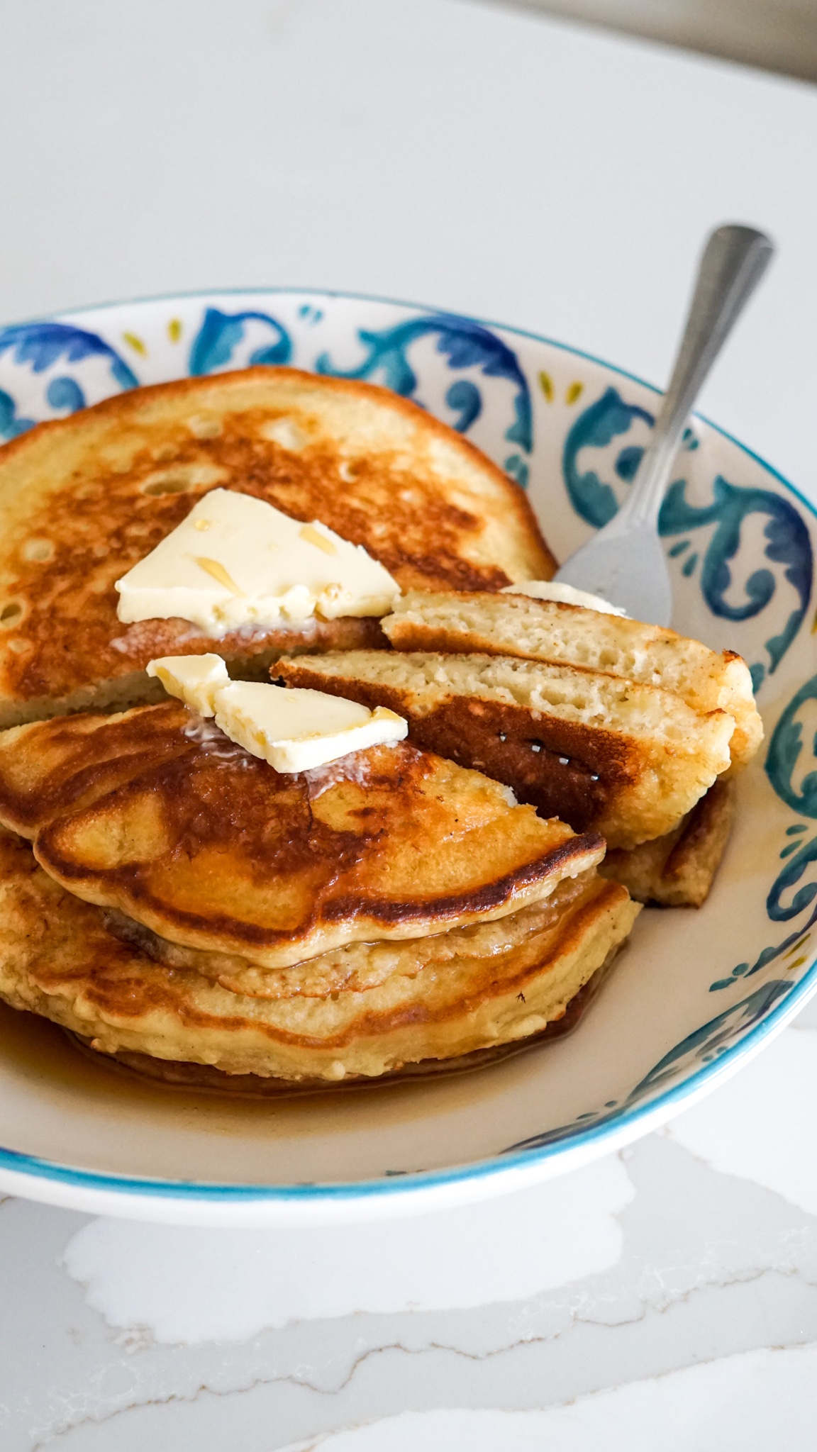 pancakes with dairy free butter on a blue and white plate