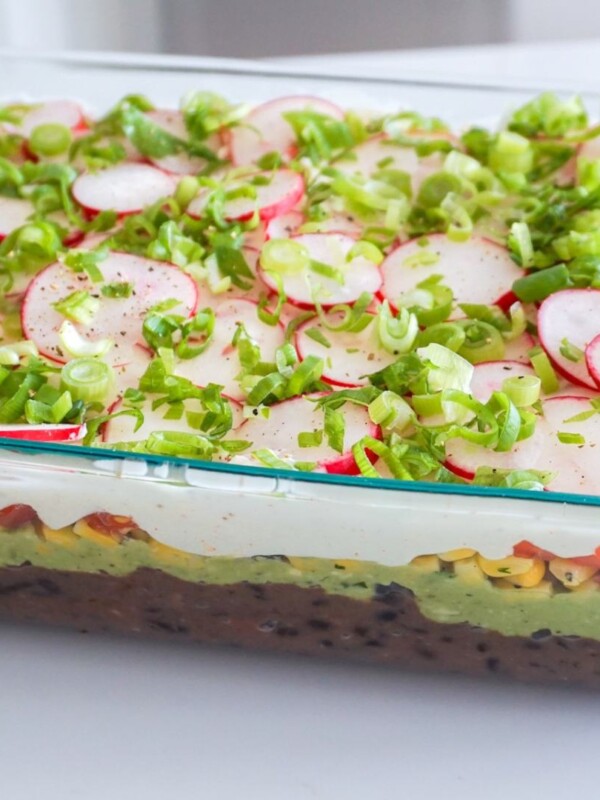 7 layer dip in a glass casserole dish on a white counter