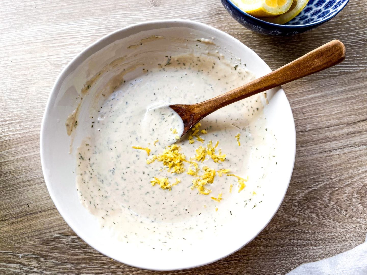 tahini dressing with lemon zest in a white bowl