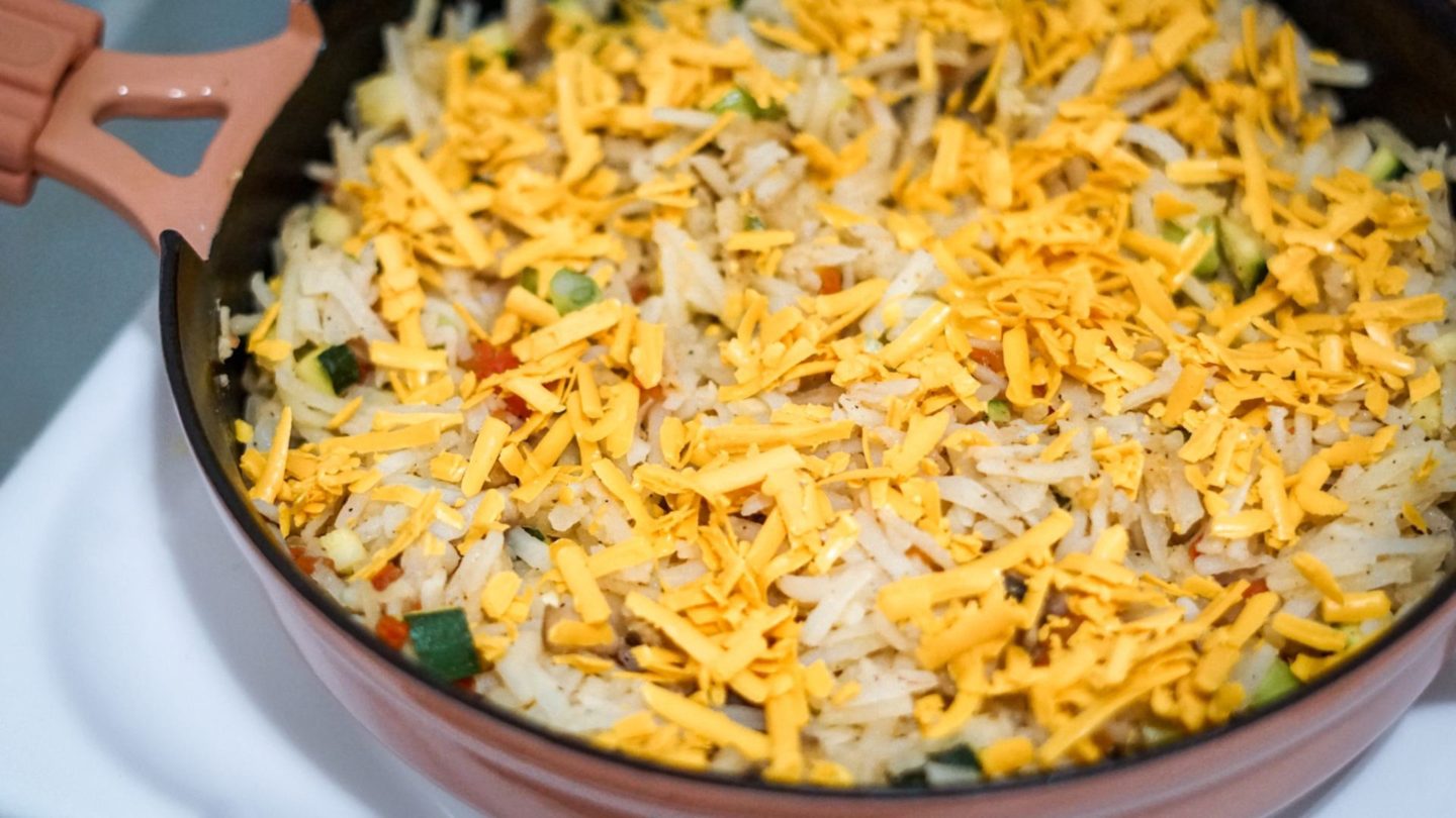 vegetables, hashbrowns and vegan cheese in a skillet