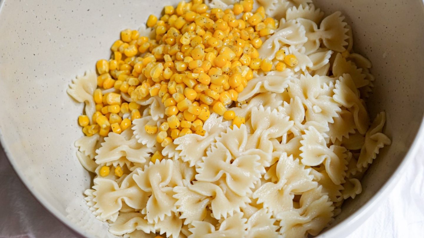 pasta and corn in a mixing bowl