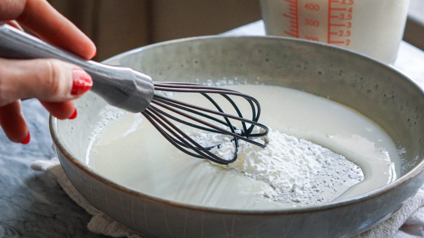 whisking cornstarch in a blue bowl