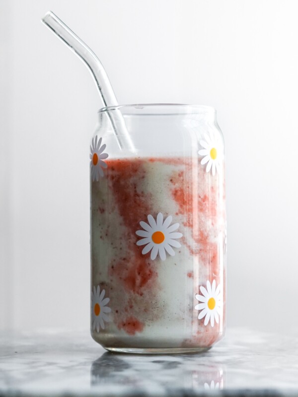 strawberry smoothie in a glass with a straw