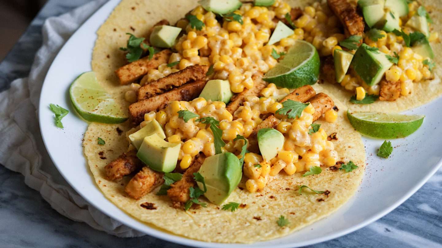 vegan chicken and corn tacos on a white plate