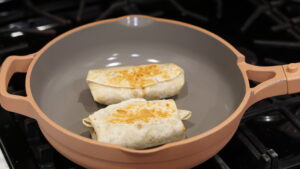 toasting burritos in a large skillet