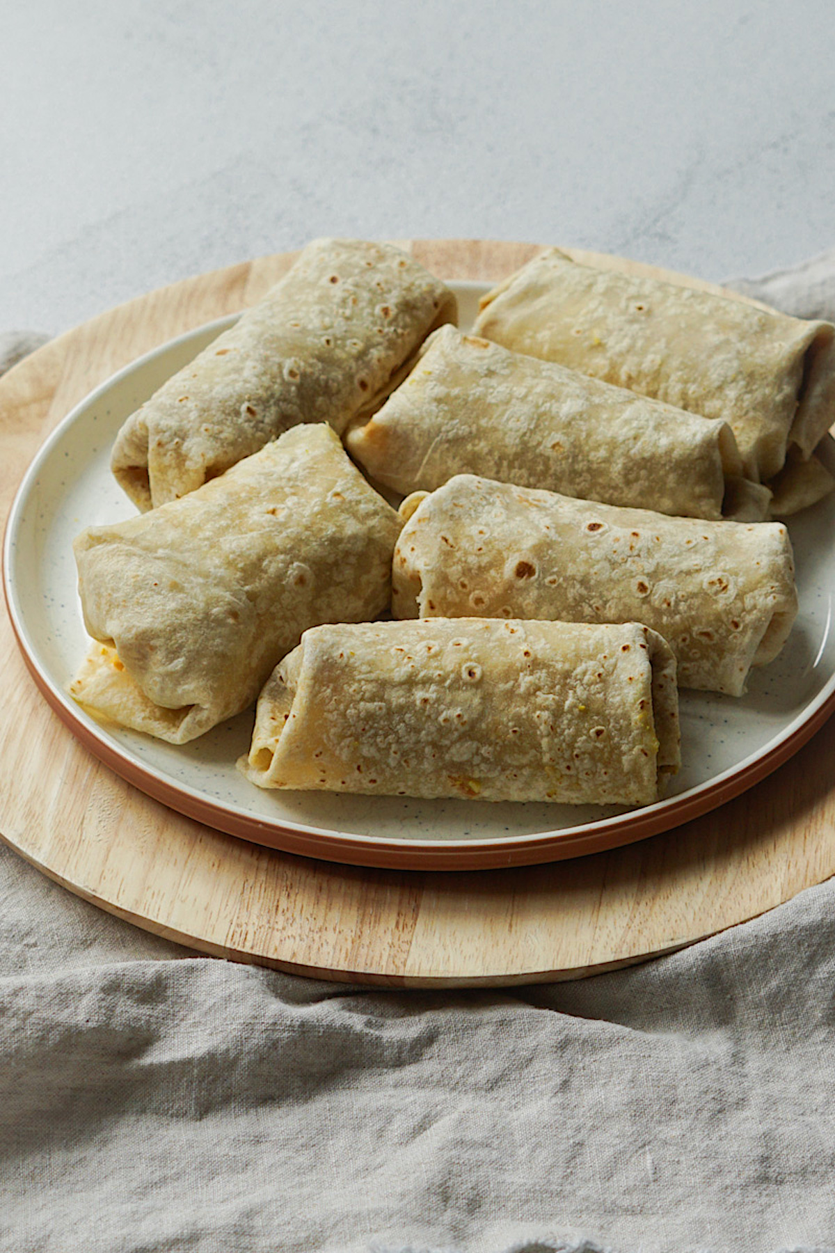 freezer friendly breakfast burritos on a white plate 