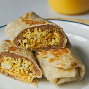 breakfast burritos sliced in half on a white plate