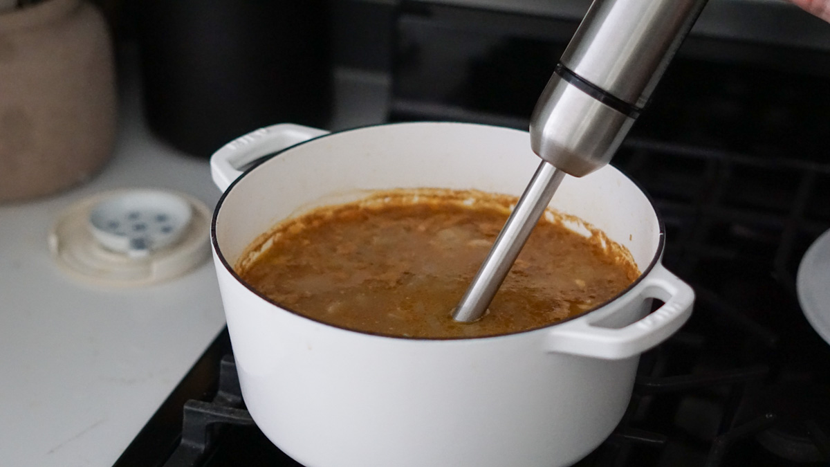 blending potato soup with an immersion blender