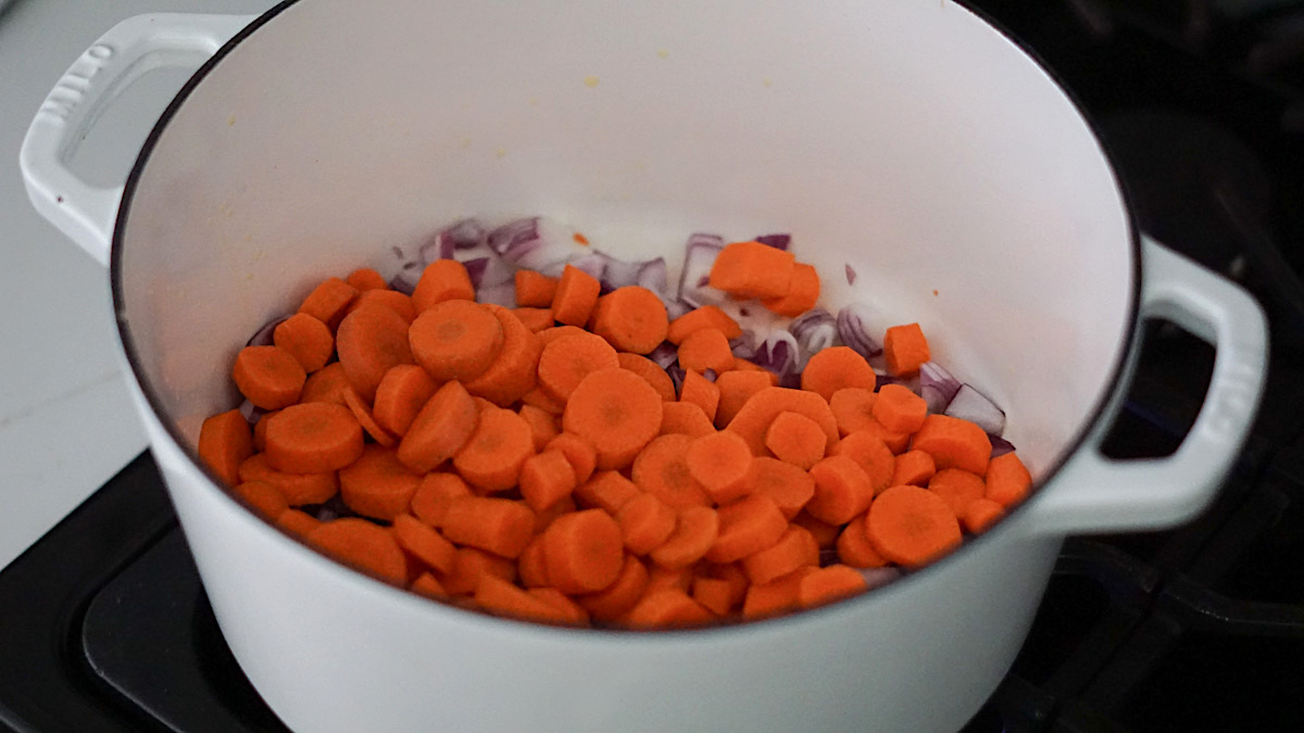 carrots and onions in a large white pot